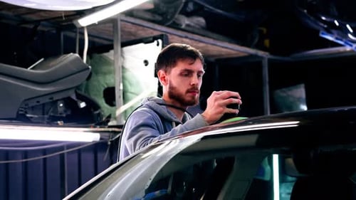the Car Mechanic at a Service Station Doing the Final Polishing to Shine