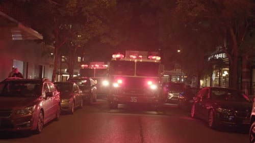 fire truck with flashing siren lights standing in the city at night