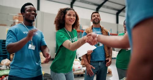 Happy Volunteers Clapping in Warehouse