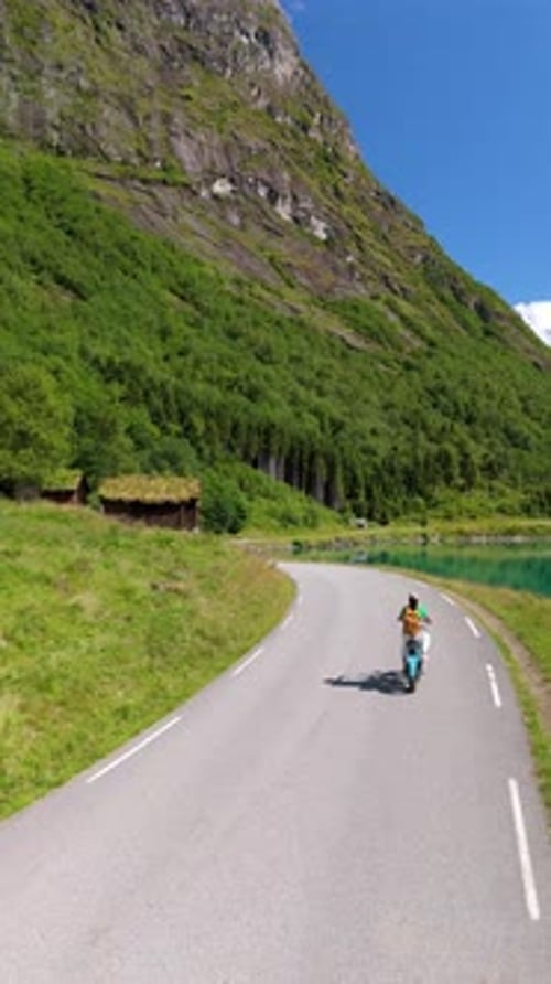 Embark on a Peaceful Ride Along an Idyllic Mountainous Road Under a Clear Blue Sky Lovatnet Norway