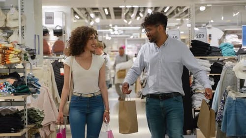 Happy Couple Carrying Shopping Bags in Clothing Store