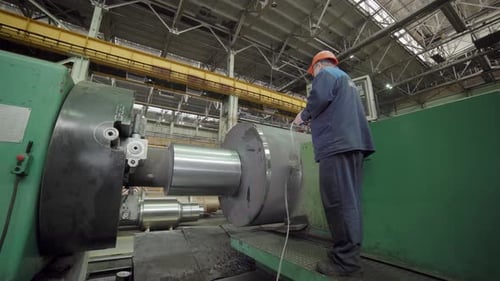 A Worker Skillfully Operating Machinery in an Industrial Factory Showcasing Their Expertise Stock