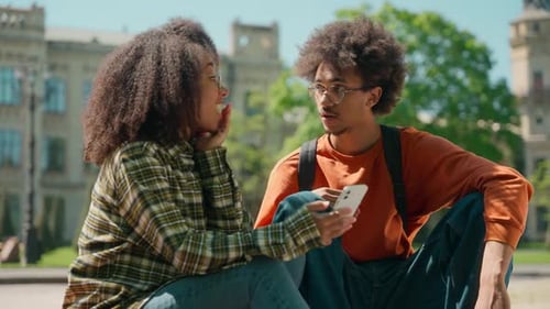 Students Sharing Phone Content on University Campus