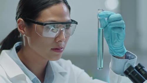 Female Scientist Holding Test Tube with Blue Liquid