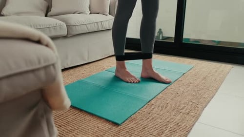 Woman Doing Leg Lifts with Resistance Band Indoors