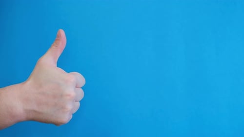 Hand Giving Thumbs Up on Blue Background