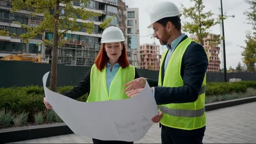 Architects Reviewing Plans on Construction Site Together