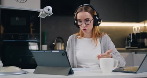 Belle femme indépendante parlant en visioconférence en ligne avec un casque, un microphone