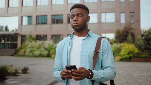 Young Man Using Phone in City Setting