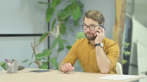 Young Man Talking on Phone in Office
