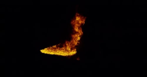 Ignite Collection: Flames soar high from a wide area of fire on ground on dark background shot in 4k