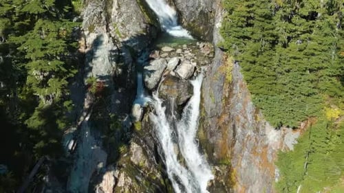 River and Waterfall Running Down the Mountain By Rocks and Trees