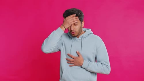 Man in Sweatshirt Coughing and Holding Chest