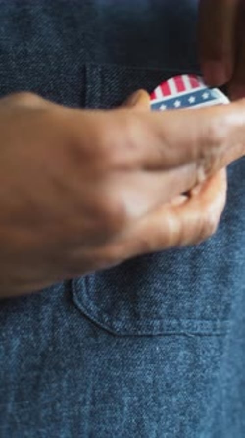 African American US Citizen Puts on Badge with USA Flag Logo