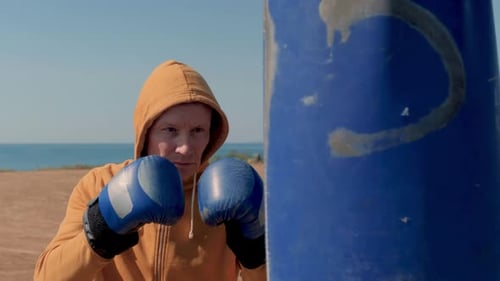 Close Up Of A Middle-Aged Man Practices Boxing On A Court By The Sea