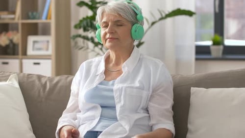 Technology, People and Lifestyle Concept - Happy Senior Woman in Headphones And