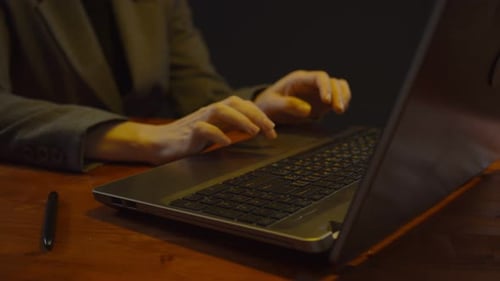 Typing on Laptop at Desk with Pen Close Up