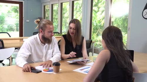 Business Team Discussing Charts and Tablet in Office