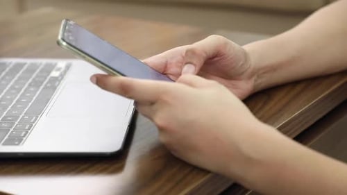 Stock video footage of woman typing on cell phone.