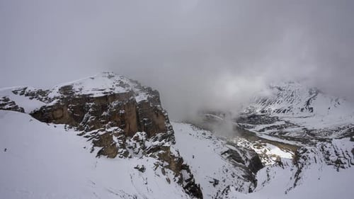 In summer, the mountain tops are covered with white clouds and snow.
