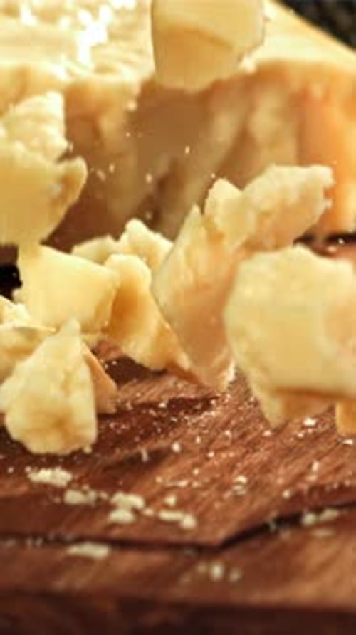 Parmesan Cheese Falls on a Wooden Board Filmed on a Highspeed Camera at 1000 Fps