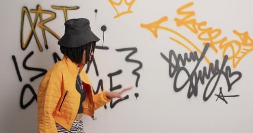 Woman Stands In Front of Graffiti Wall Art