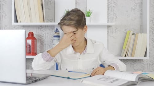 L'enfant qui a mal aux yeux en étudiant.