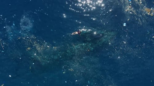 Menschen schwimmen im dreckigen Ozean mit schwimmender Plastikverschmutzung von oben