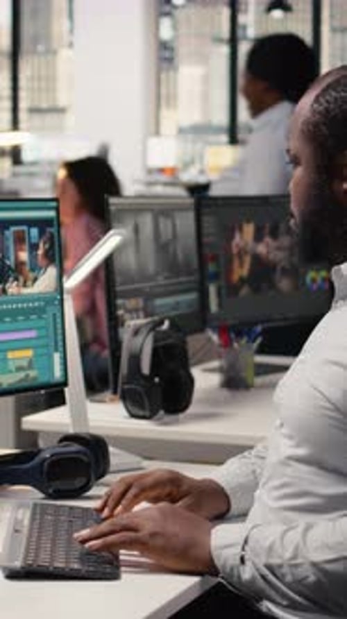 Man working on computer in busy office environment