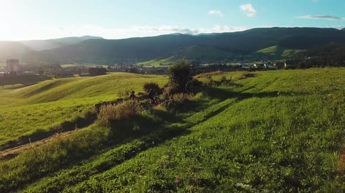 Aerial side view of mountain bikers on a dirt trail in the mountains. People on bicycles riding thro