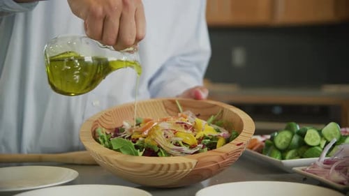 Preparing a fresh salad with olive oil