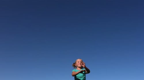 Young Girl Jumps Barefoot Against a Bright Blue Sky
