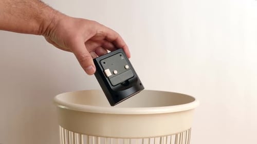 E36. A broken watch is thrown into the trash can. Disposal of household waste.