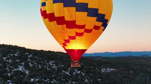 Hot Air Balloon Over Forest at Sunrise
