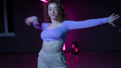 Live Camera A Dancer Skillfully Dances Modern Dance in a Choreographic Hall with Neon Illuminated