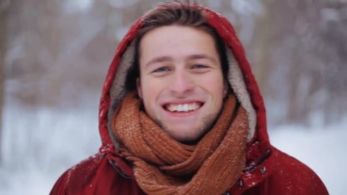 People, Christmas, Winter, Season And Emotion Concept - Happy Smiling Man In Hood And Scarf Outdoors