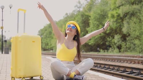 Woman with Suitcase Awaits Train on Platform