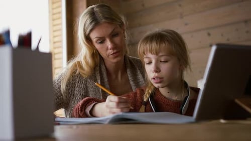 Woman Helping Child with Homework at Home