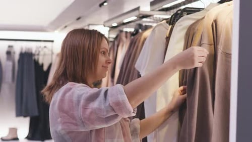 Girl Choosing Clothes in a Clothing Store Shop Shopping Concept