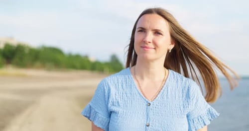 A Beautiful Woman Enjoys Relaxing Walking on the Beach on Her Summer Vacation