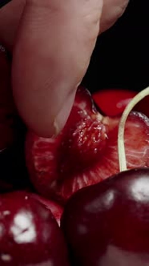 Close Up of a Finger Pressing a Cherry