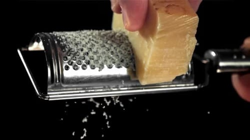 Cheese Block Being Grated with a Metal Grater