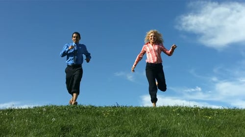 Man and Woman Running Down Grassy Hill,