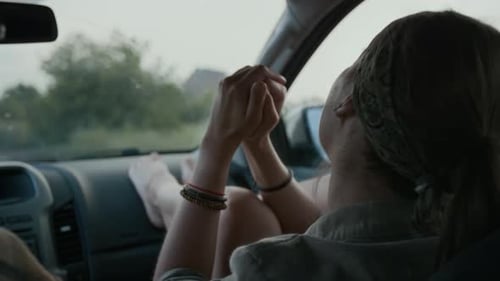 Happy Girl Singing to Radio while Riding in Car with Boyfriend on Vacation