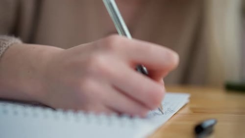 Woman Writing in Notebook Close Up