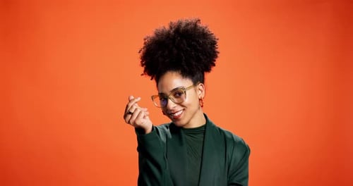 Happy, love and face of woman by studio background for kindness, care and gratitude hand sign