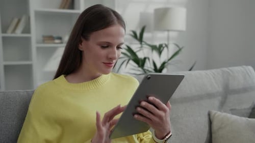 Woman Using Tablet at Home on Couch