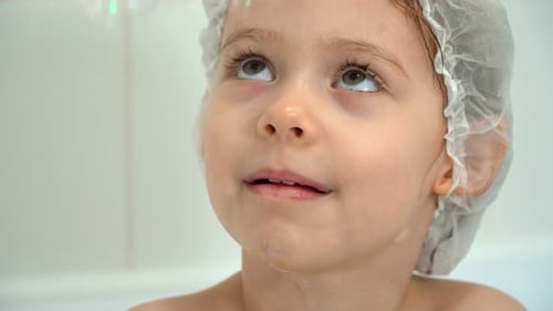 Close Up of Little Girl Fun Bathes in Bath with Soap Bubbles and Laughs