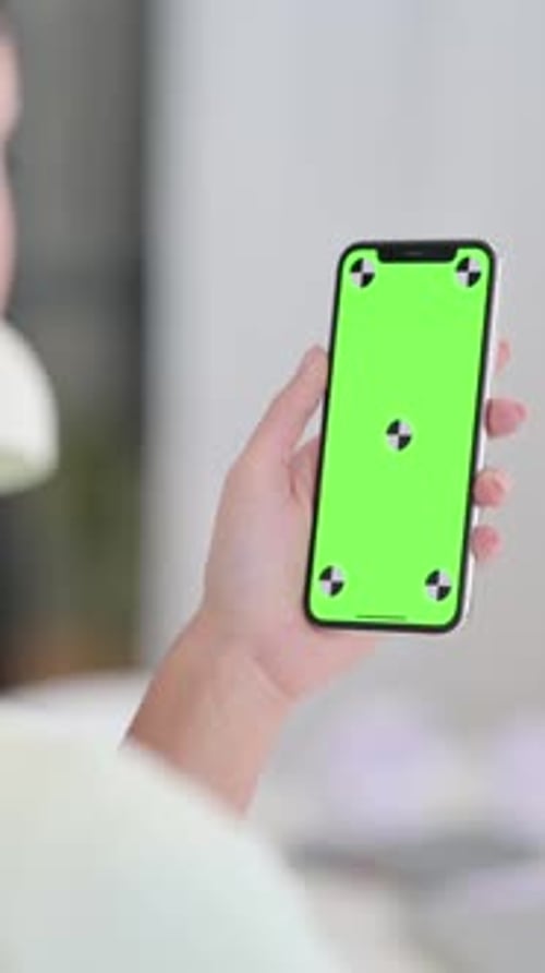 Smartphone with Green Screen in Hand in Home