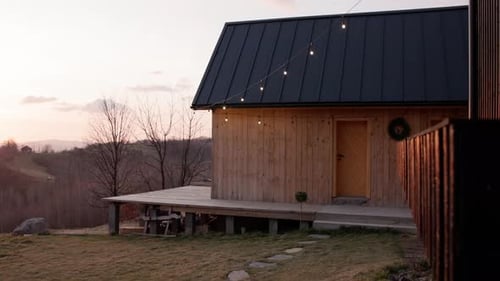Rural Cabin with String Lights at Sunset